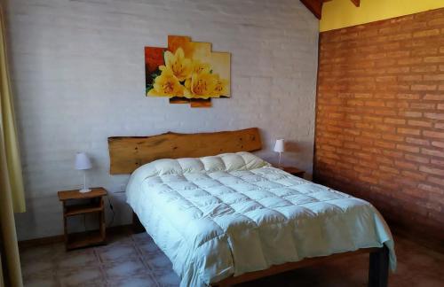 una camera da letto con un letto e un quadro sul muro di Cabañas La Delfina para 4 personas Potrero de los Funes a Potrero de los Funes