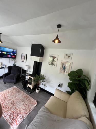 un salon avec un canapé et une télévision dans l'établissement Storeybook cottage, à Oswestry