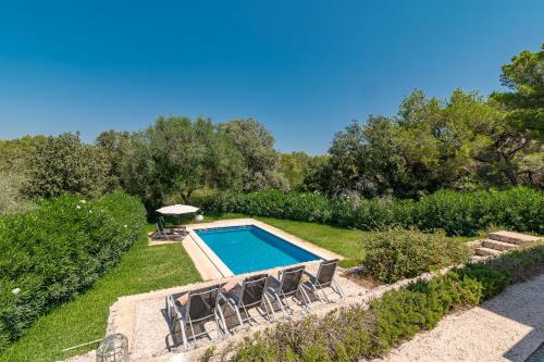 a swimming pool in a yard with chairs around it at Villa Comellar by Sealand Villas in Artá