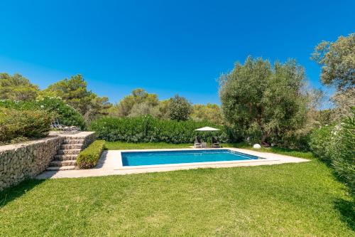 a swimming pool in a garden with a lawn at Villa Comellar by Sealand Villas in Artá