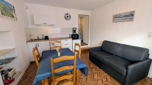 una sala de estar con una mesa y un sofá en Gîte des hauts gris, en Vions