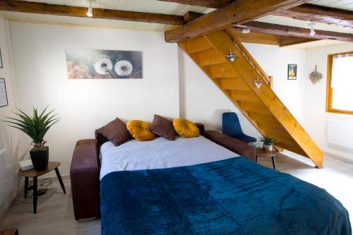 a bedroom with a large bed and a staircase at L'authentique bleuet d'Alsace in Wettolsheim