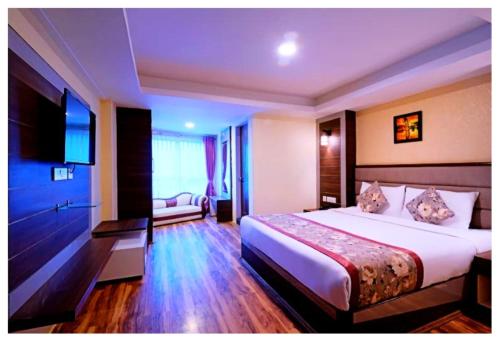 a hotel room with a bed and a television at Hotel Zambala Retreat & Spa Darjeeling in Darjeeling