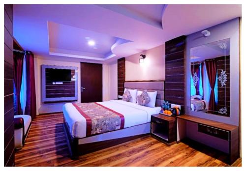 a bedroom with a large bed and a television at Hotel Zambala Retreat & Spa Darjeeling in Darjeeling