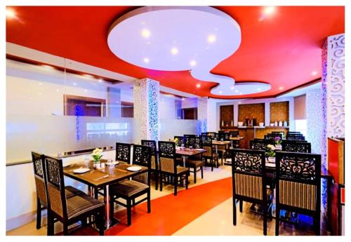 a restaurant with tables and chairs and a white ceiling at Hotel Zambala Retreat & Spa Darjeeling in Darjeeling