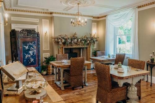 a dining room with tables and chairs and a fireplace at Lydford House in Lydford