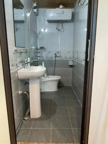 a bathroom with a sink and a toilet and a shower at The Rose House-Lakeview Long Bien in Hanoi