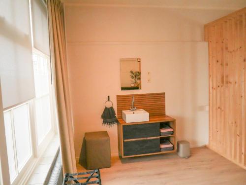 a small room with a sink and a mirror at De Kazerne - Kiersche wijde in Wanneperveen