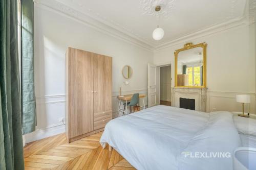 ein Schlafzimmer mit einem Bett, einem Spiegel und einem Tisch in der Unterkunft Cozy Room in Alésia Paris 14th in Paris
