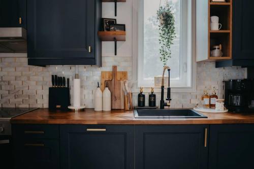 a kitchen with black cabinets and a kitchen sink at The Hideout in Barrie