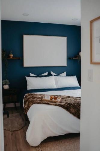 a bedroom with a large bed with a blue wall at The Hideout in Barrie