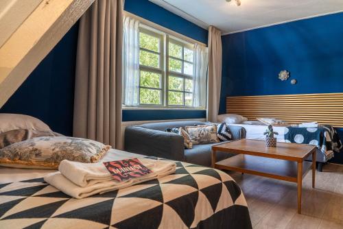 a blue room with a bed and a couch at Duinlust Dishoek in Dishoek