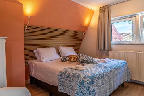a small bedroom with a bed with a window at Duinlust Dishoek in Dishoek
