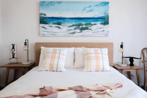 Un dormitorio con una cama y un cuadro en la pared. en The Shack on Caffrey - Port Willunga, en Port Willunga