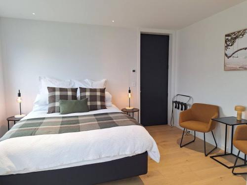 a bedroom with a large bed and two chairs at Alpine Hideaway Studio in Wanaka
