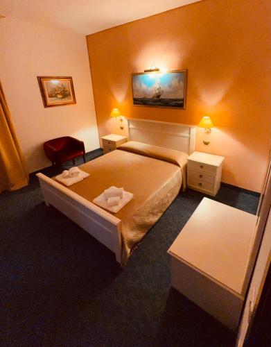 a hotel room with a bed and two tables at Hotel Rey's in Montegrotto Terme