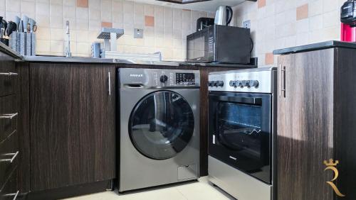 a kitchen with a dishwasher and a washing machine at Hydra C6 Studio - Luxe View Retreat in Abu Dhabi