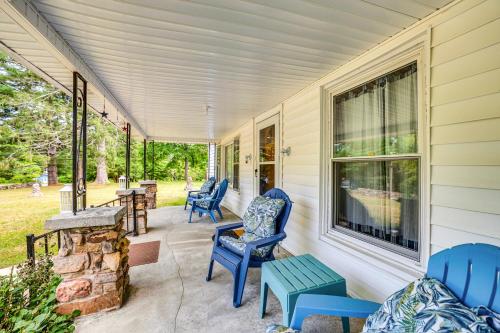 a porch with blue chairs and a stone fireplace at Historic Hawkins House Located on Sewanee Campus in Sewanee