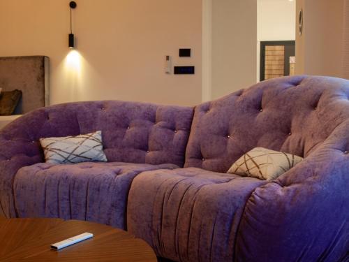 a purple couch in a living room with a table at NOVA LUXURY DESIGN in Zagreb