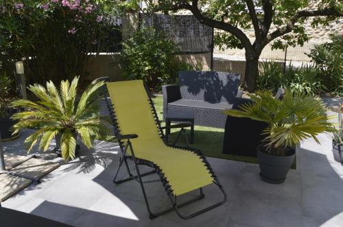un patio con 2 sillas, una mesa y plantas en Au temps présent, en Oraison