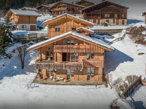 una vista aérea de una cabaña de madera en la nieve en Chalet Aravista - OVO Network, en Le Grand-Bornand