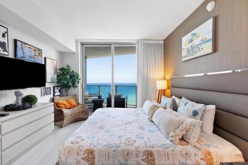 Un dormitorio con una cama grande y un televisor. en Picturesque Beachfront Condo - LOVELY 2BD and 2BA APT WITH DIRECT OCEAN VIEW, en Hollywood