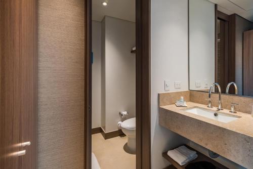 a bathroom with a sink and a toilet at Hampton By Hilton Bogota Airport in Bogotá
