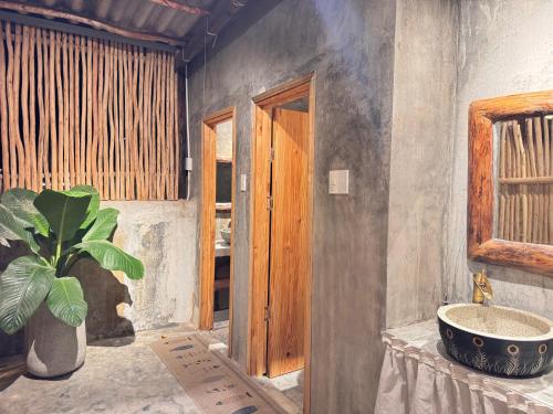 La salle de bains est pourvue d'un lavabo et d'une plante en pot. dans l'établissement MIA Villa, à Tiến Thành