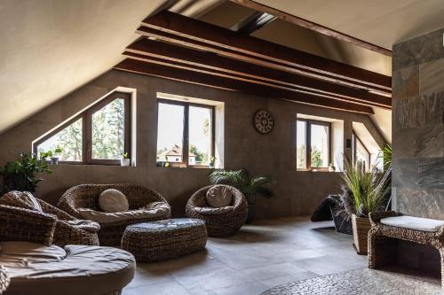 una sala de estar con muebles y ventanas de mimbre. en Wellness Hotel Demänová, en Liptovský Mikuláš