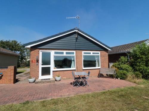 a house with a table and chairs in the yard at Beach House in Filey