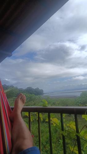 a person sitting in a hammock looking out at the ocean at casa guayaba lodge in Nuquí
