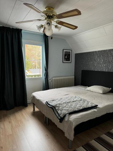 a bedroom with a bed with a ceiling fan at Stensele house in Stensele
