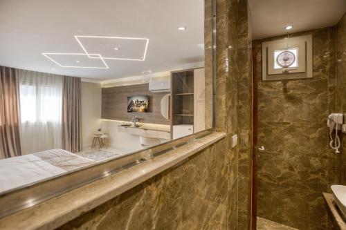 a bathroom with a large mirror and a shower at Secrets Of The Pyramids Hotel in Cairo