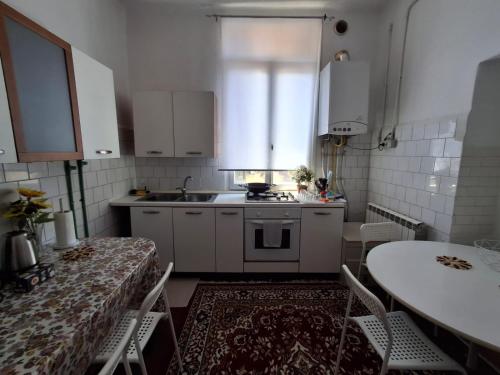a kitchen with white cabinets and a sink and a table at Venetian Haven BnB in Venice