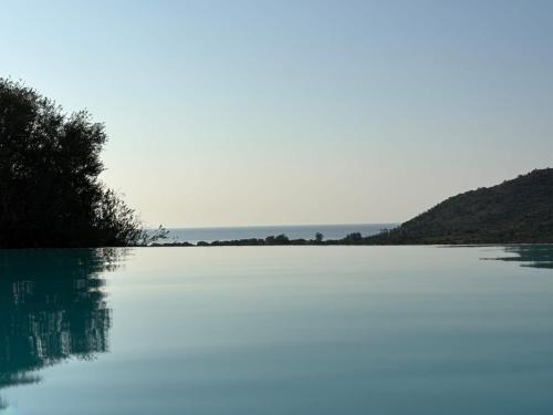 タナウネッラにあるAlba Vista Mare - Apartment mit Meerblick und Pool Budoni, Sardinienの山を背景にした湖の景色