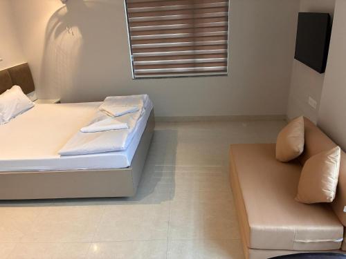 a small bedroom with a bed and a couch at Swarn Hotel in Kolkata