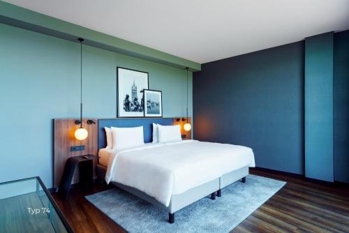 a bedroom with a large white bed and blue walls at ScanHotels City in Rostock
