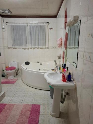 a bathroom with a tub and a sink and a toilet at Presitige Vacation Stay in Nairobi