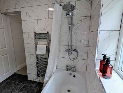 ウォルヴァーハンプトンにあるContractors 4BR Home, Newly Refurb, Nr Centreのバスルーム(白いバスタブ、シャワー付)