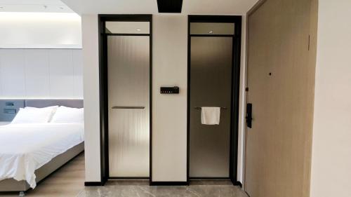 a bedroom with two doors leading to a bed at Haisi Boya International Hotel in Donghai