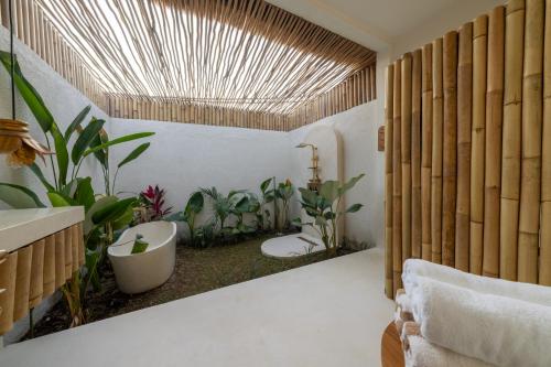a bathroom with plants and a tub and a sink at Aloha Boutique Uluwatu in Uluwatu