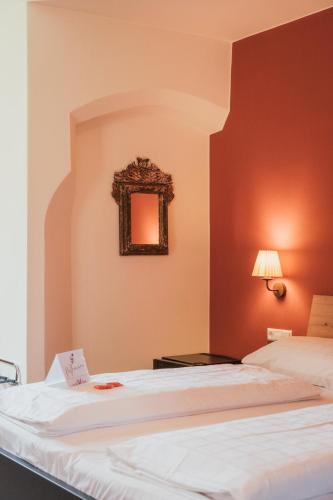 two beds in a room with a mirror on the wall at Hotel Traube in Bressanone