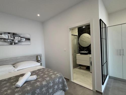 a bedroom with a bed and a bathroom with a mirror at Apartment Hortenzija in Baška Voda