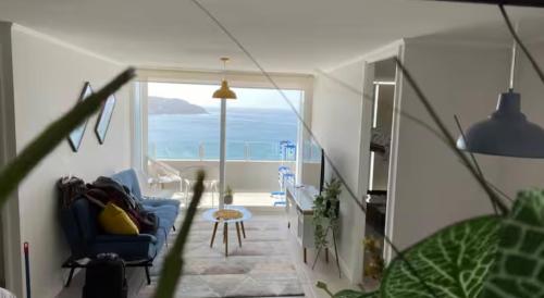 a living room with a blue couch and a view of the ocean at Frente al mar primera linea in Coquimbo
