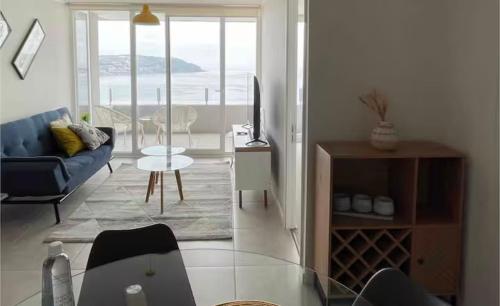 a living room with a blue couch and a glass table at Frente al mar primera linea in Coquimbo
