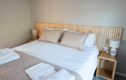a bedroom with a bed with white sheets and pillows at Refugio Andino Los Queñes in El Cerrillo
