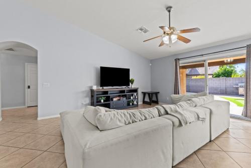 a living room with a couch and a flat screen tv at Pool Oasis 4Br Golf, Ping-Pong, Cornhole Retreat in Glendale