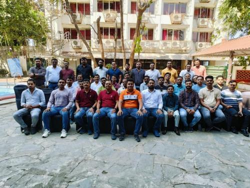 a group of men posing for a picture in front of a building at Presidency Landmark in Daman