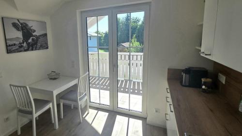 a kitchen with a table and chairs and a balcony at Ferienwohnung Peter in Steingaden