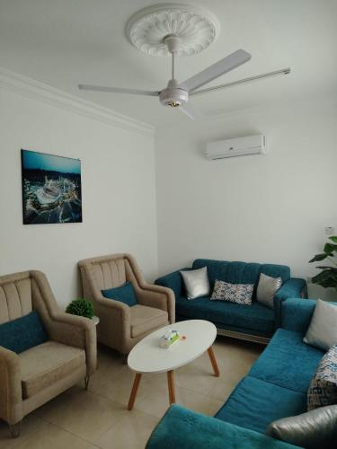 un salon avec des canapés bleus et une table dans l'établissement العقبة, à Aqaba